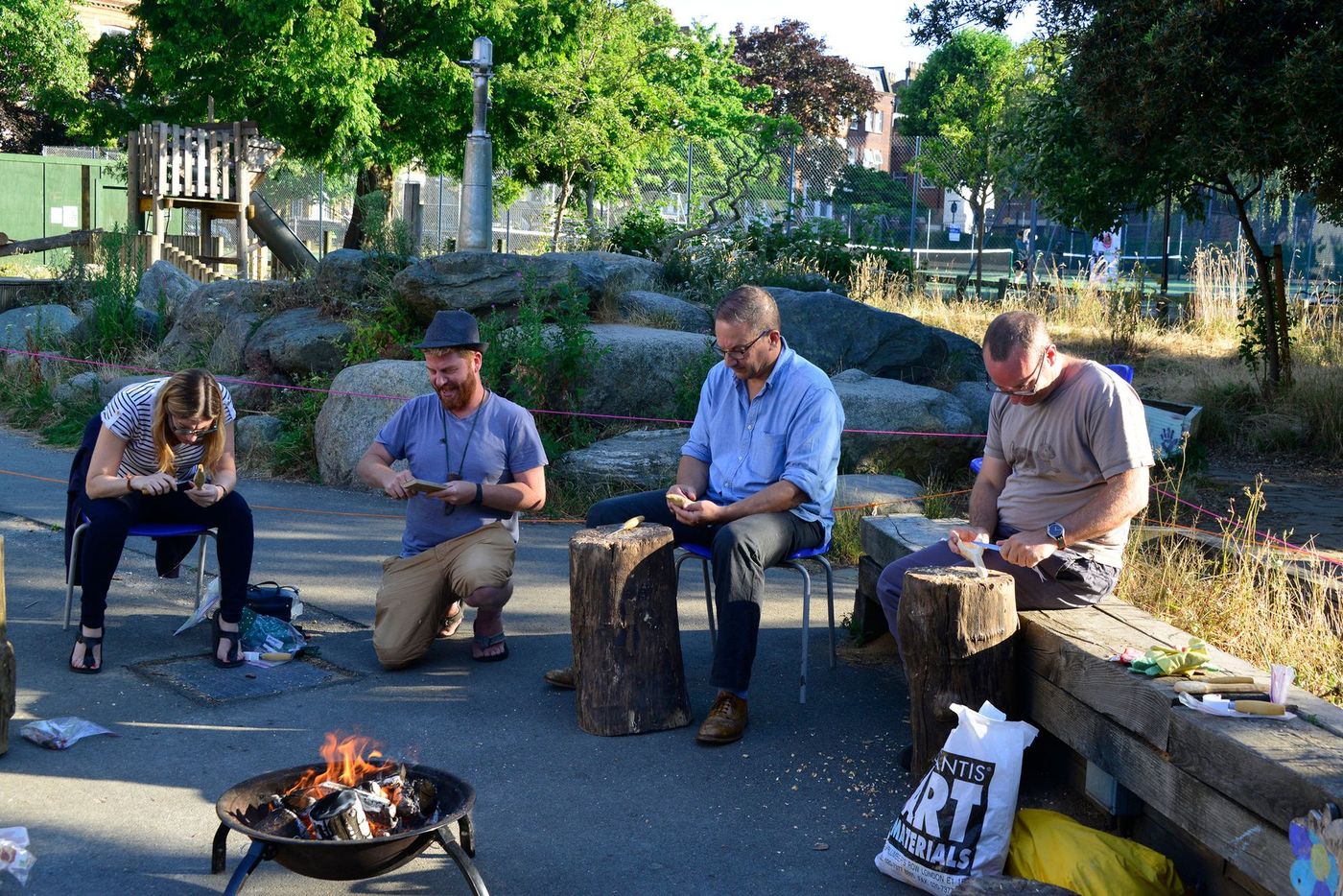 Adults learning spoon carving outdoors