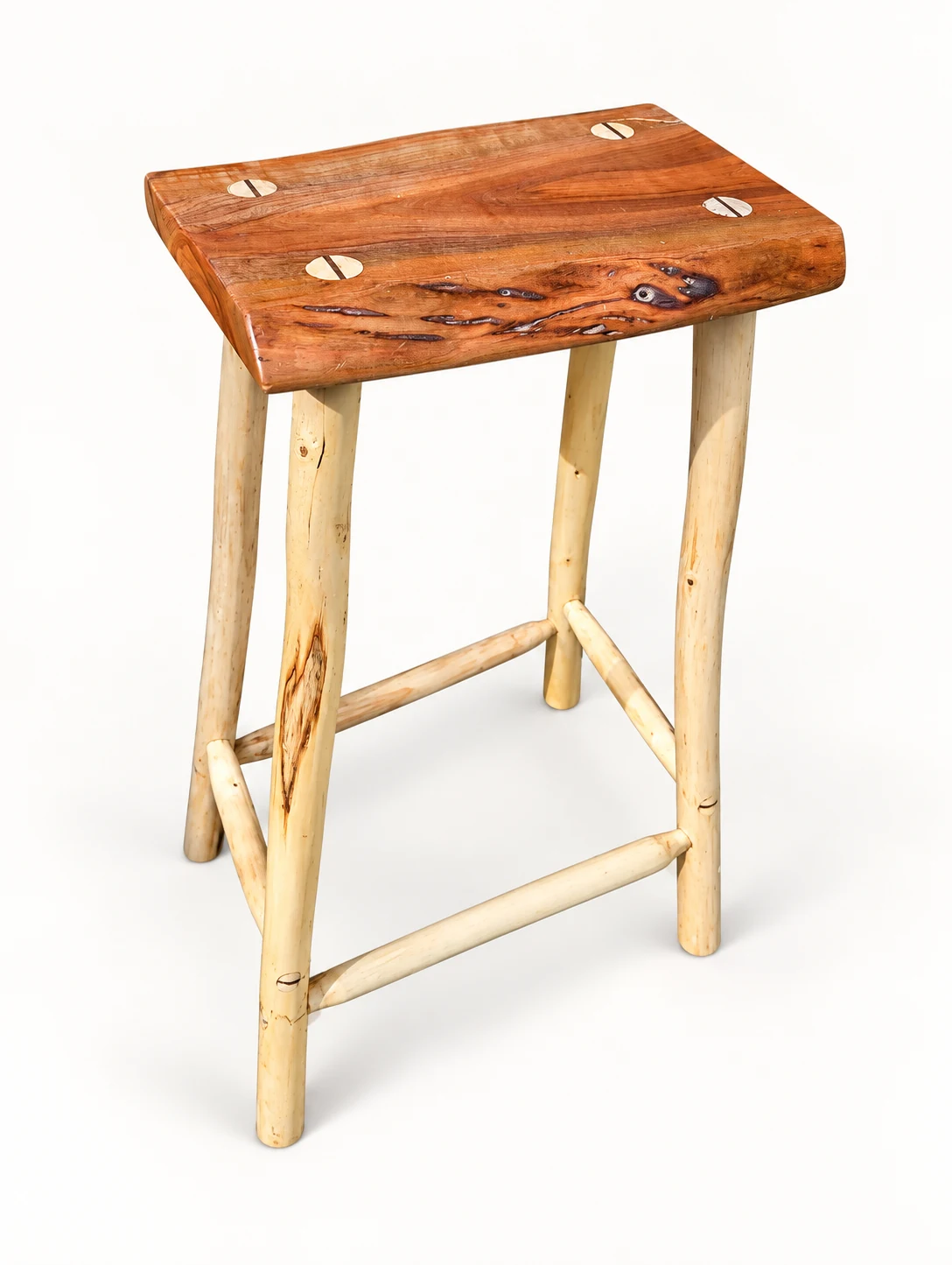 Finished handmade wooden stool with a reddish seat and pale legs on an off-white background