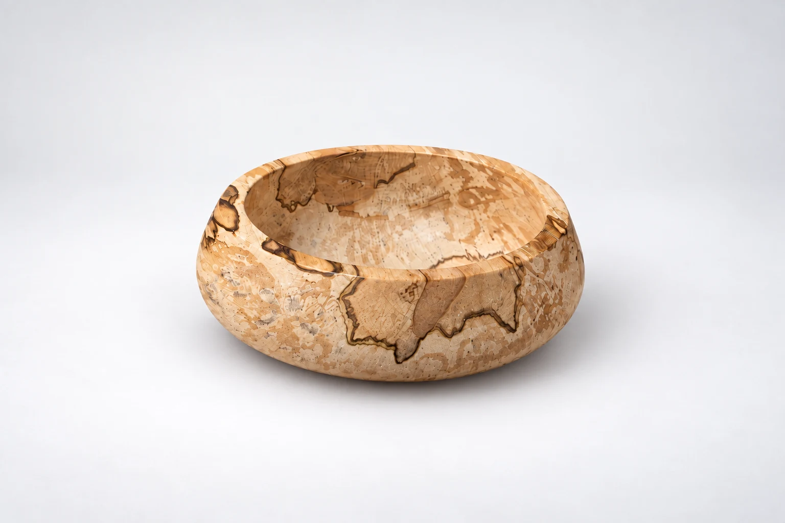 Spalted wooden bowl with dark grain markings and an uneven rim