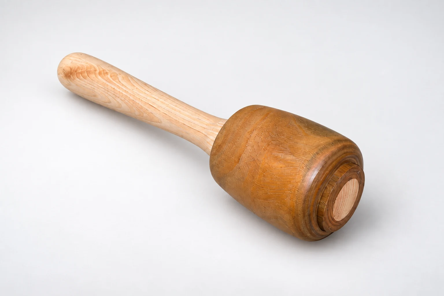 Wooden mallet resting diagonally against a white background