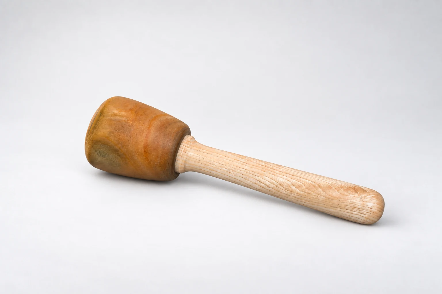 Side view of a wooden mallet showing its head and handle